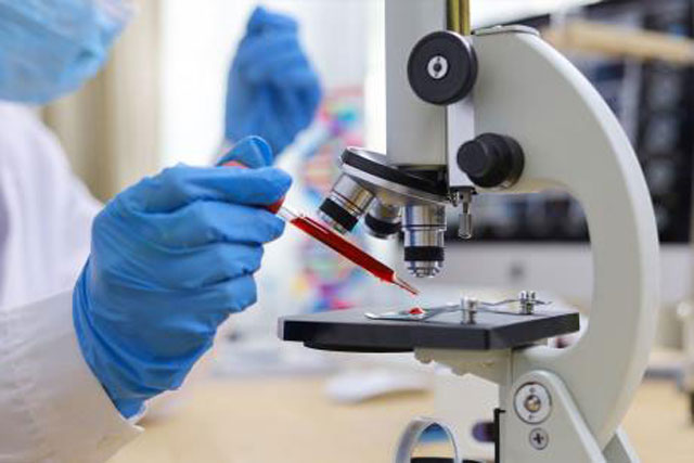 Doctor Placing Blood Drop in Microscope to Examine
